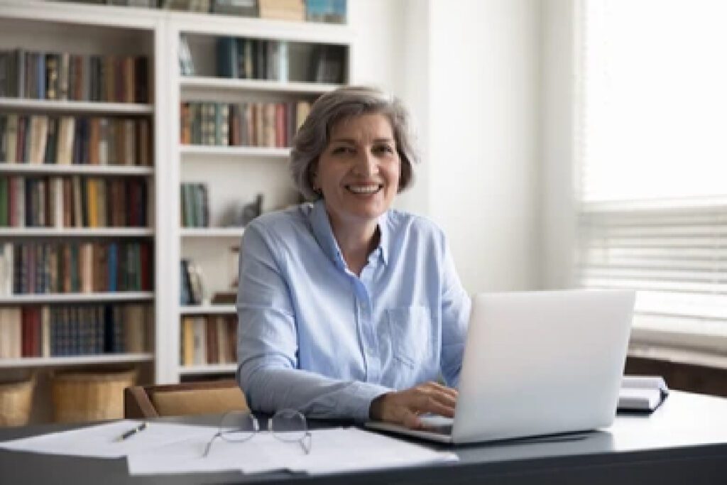 Legislation being read by a smiling professional woman seated at desk with laptop